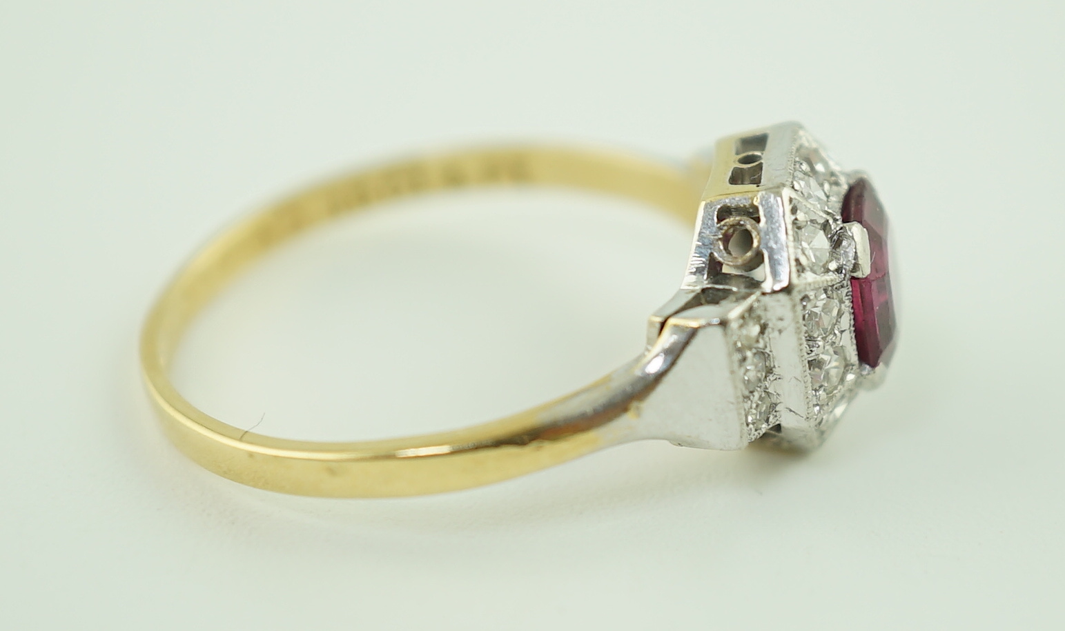 A 1950's Art Deco 18ct gold and platinum, ruby and millegrain set diamond octagonal cluster ring